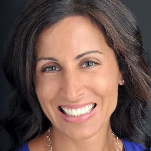 Close up headshot of brunette woman smiling.