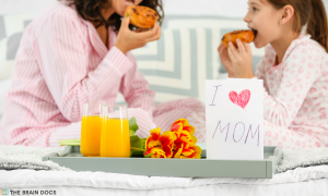 A mother and daughter eating a healthy breakfast recipe in bed on Mother's Day.